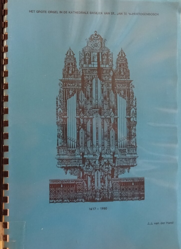 Ein Buch mit einem Bild einer Kirche mit hohem Turm und Glockenturm, das auf einer Oberfläche liegt, mit Text, der wahrscheinlich die Geschichte der Kirche beschreibt.