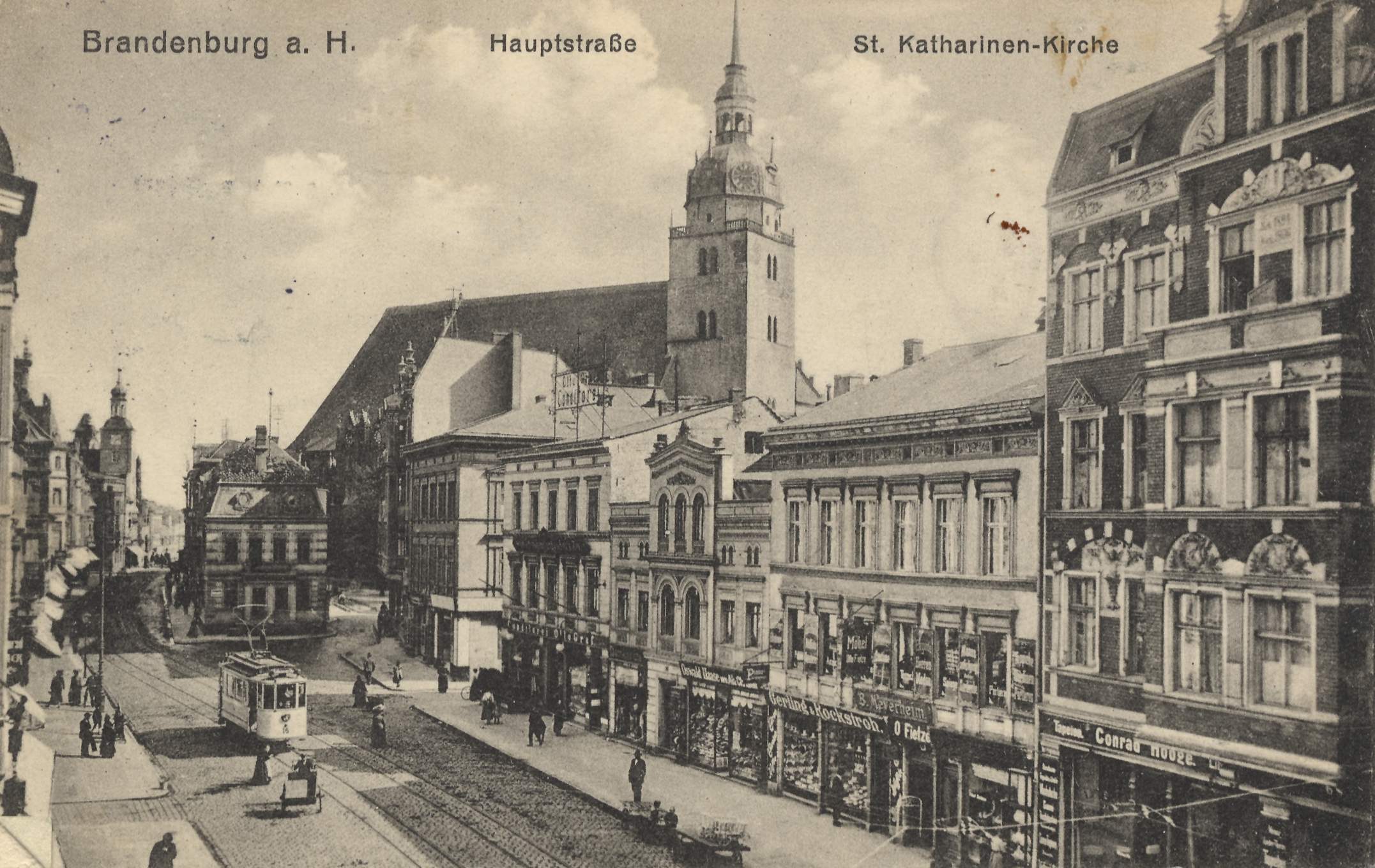 Altes Schwarz-Weiß-Foto einer Stadtstraße in Brandenburg, Deutschland, mit einer Straßenbahn auf Schienen, Fußgängern, Gebäuden mit Fenstern und einem bewölkten Himmel, mit Text oben und unten.