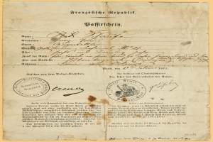 Ein altes, vergilbtes Dokument mit einem kreisförmigen, schwarz umrandeten Stempel, wahrscheinlich ein Brief der deutschen Regierung, geschrieben in schwarzer Tinte.