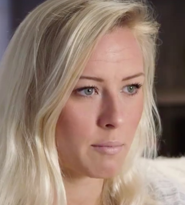 Blonde Frau mit blauen Augen in Not, Hintergrund unscharf.