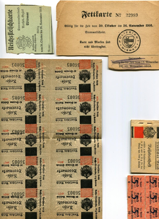 Eine Sammlung von alten, abgenutzten deutschen Eintrittskarten und Briefmarken auf einem weißen Hintergrund mit gedrucktem Text und Zahlen.