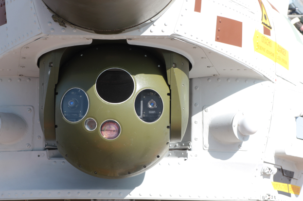 Nahaufnahme eines Militärfahrzeugs mit einer runden, grünen und weißen Rakete, die seitlich auf einem Metallrahmen montiert ist.