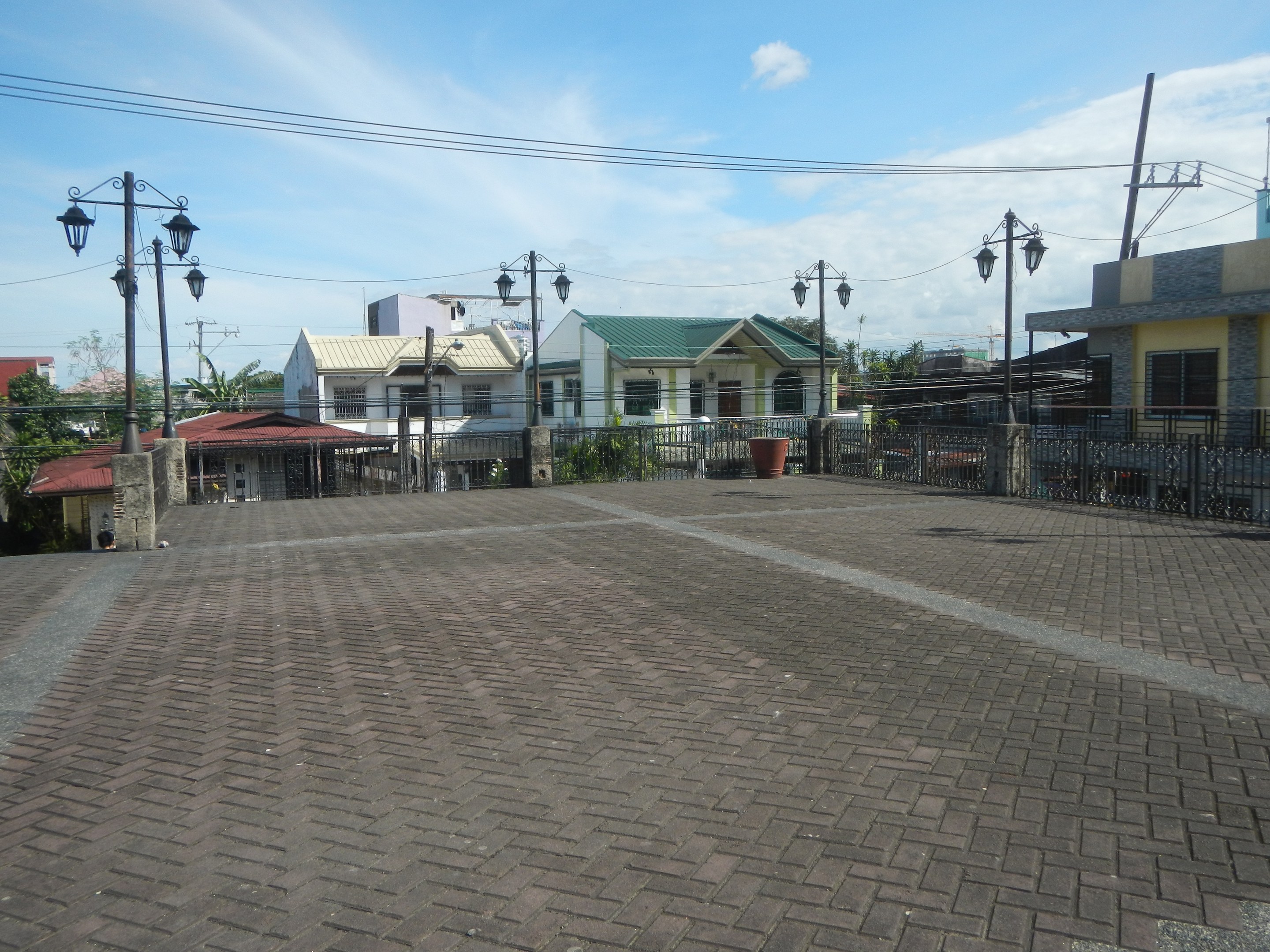 Leeres Stadtparkhaus umgeben von Gebäuden, Straßeninfrastruktur, Grünflächen und einem bewölkten Himmel.