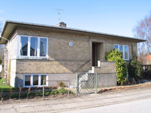 Zweizimmer-Doppelhaushälfte zum Verkauf in St Johns Wood, Swindon, mit Dach, Fenstern, Tür, Treppe, Metallzaun, Pflanzen, Gras, Bäumen, Satellitenschössel und einer bewölktem Himmel.