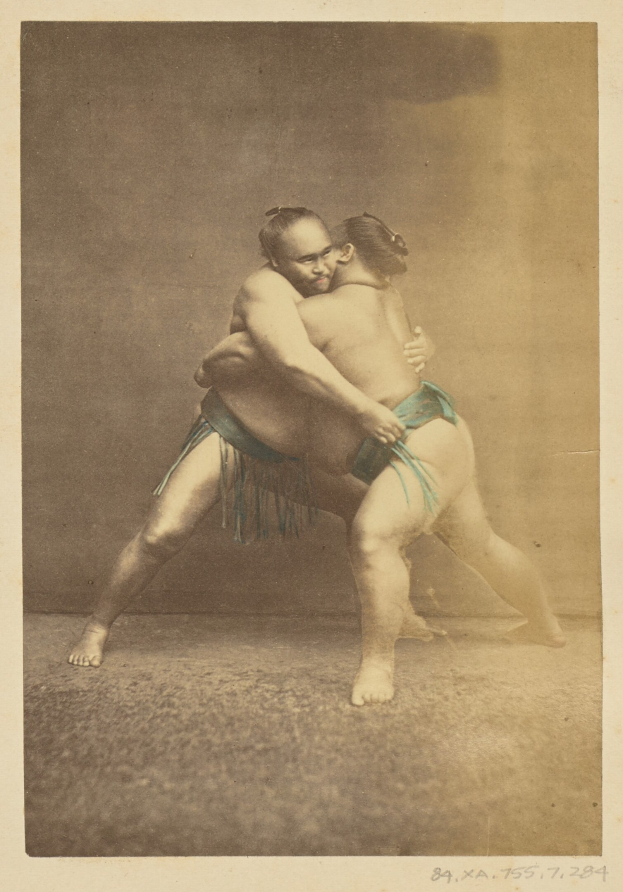 Schwarzes und weißes Foto von zwei Sumo-Ringern im Kampf mit dem Text "Sumo-Ringer" unten.
