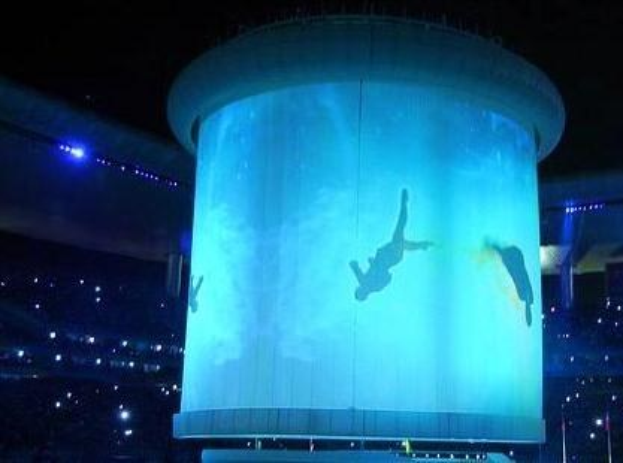 Großes beleuchtetes Stadiondisplay zeigt ein Personenbild während der Eröffnungszeremonie der Olympischen Sommerspiele 2012 nachts.