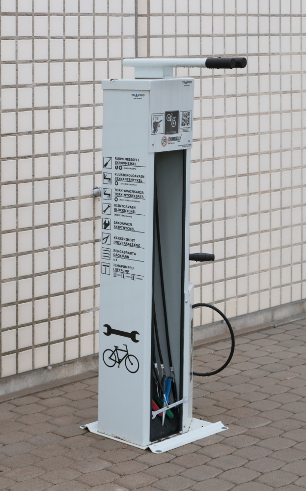 Ladestation für Elektrofahrzeuge mit einer Maschine auf dem Boden und einer Gebäudewand im Hintergrund.