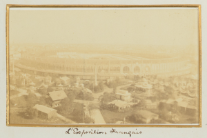 Altes Schwarz-Weiß-Foto eines Stadions umgeben von Gebäuden, Bäumen und Strommasten mit Text unten.
